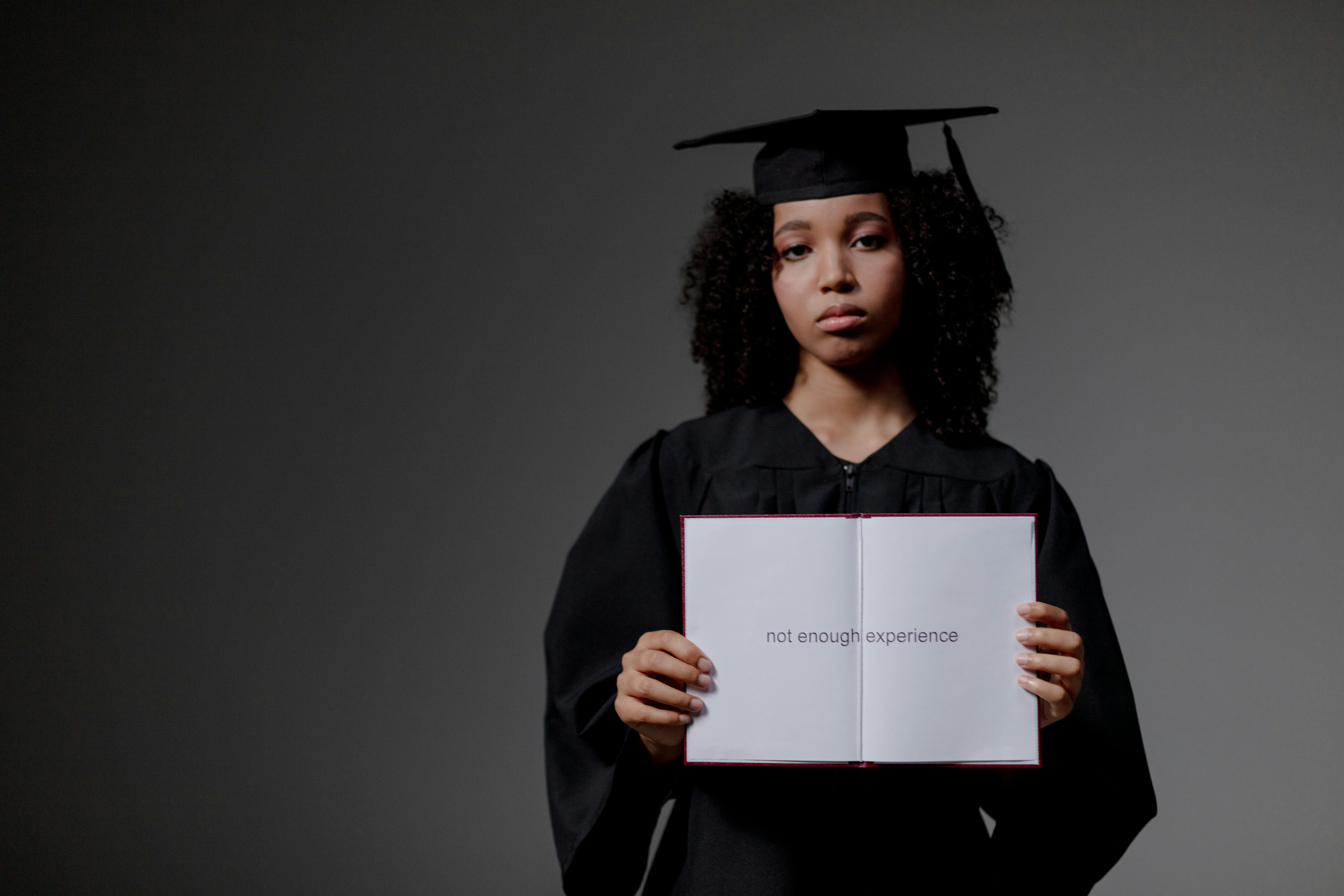 female graduate holding an unemployed status paper